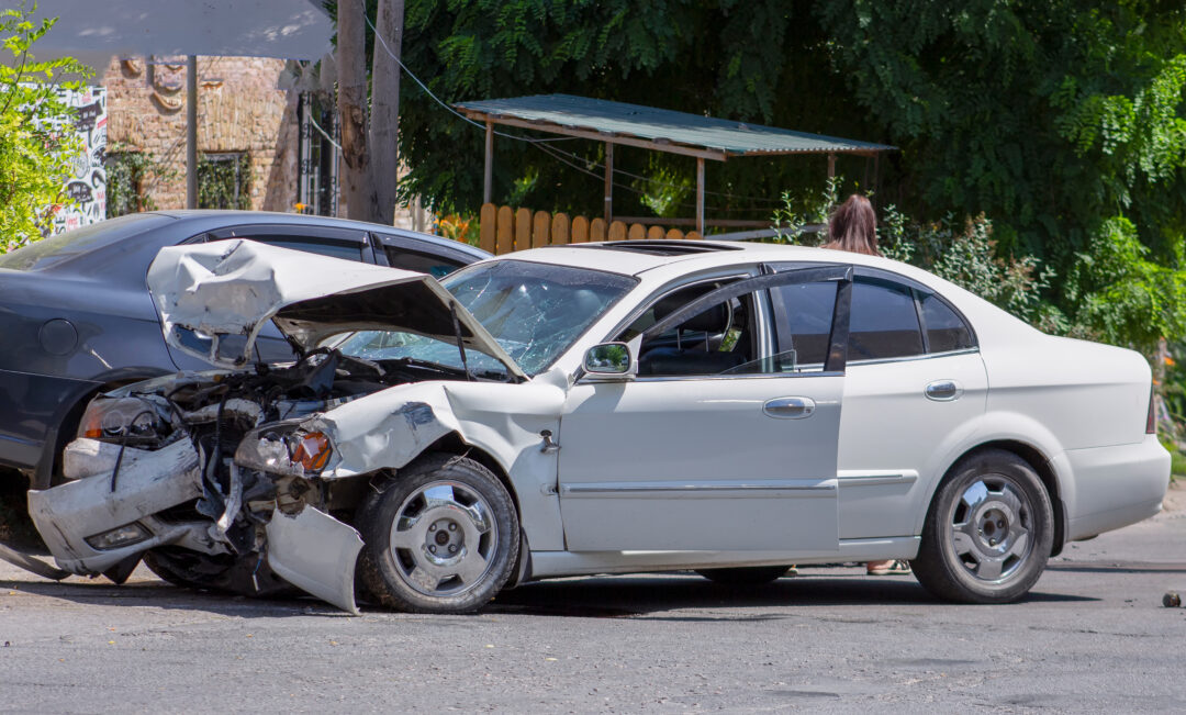 A white car with severe front-end damage after a collision, possibly from a hit-and-run accident. For legal help, contact a Missouri City hit and run lawyer."